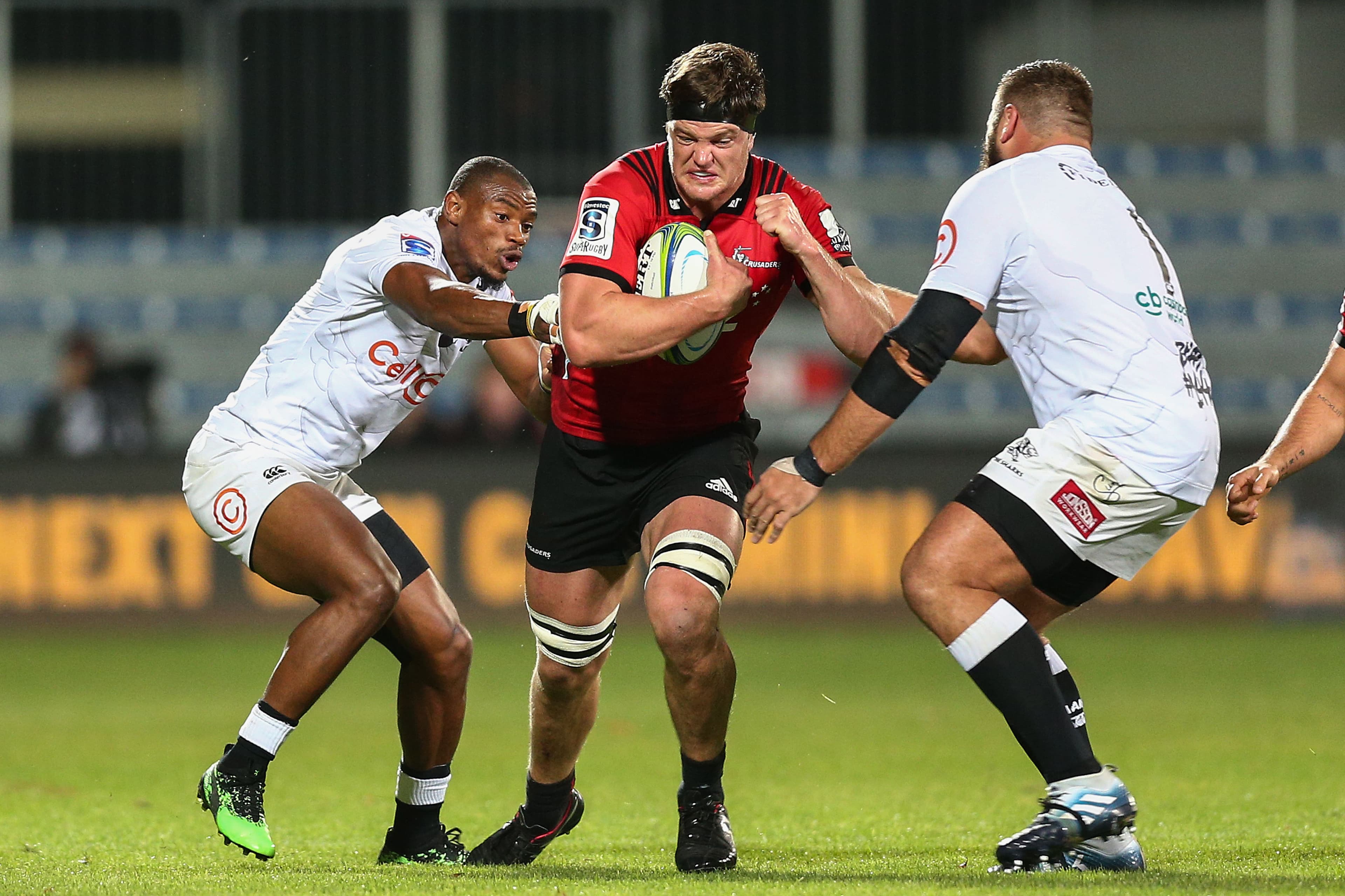 Scott Barrett of the Crusaders attempts to evade Makazole Mapimpi and Thomas du Toit of the Sharks