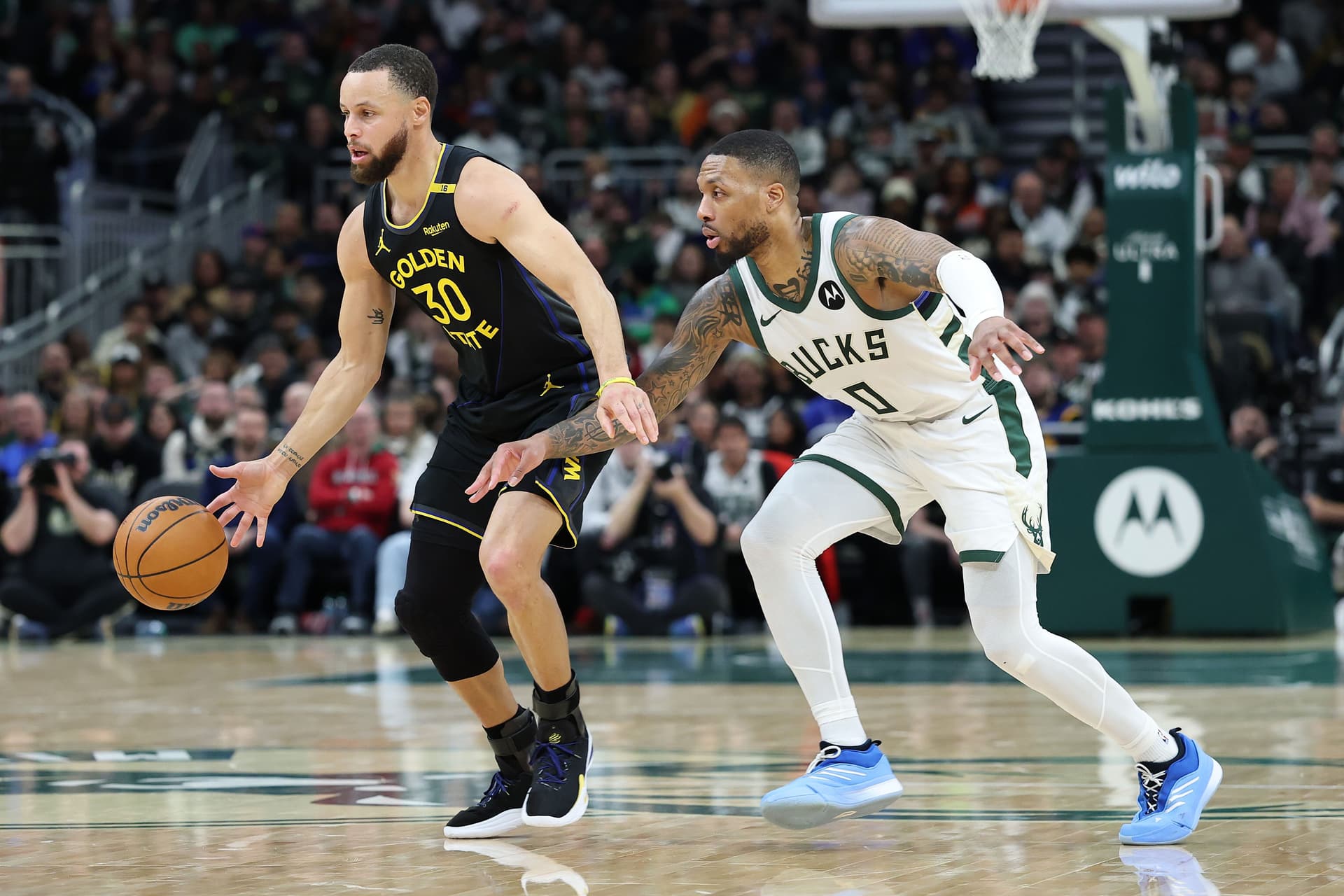 Stephen Curry is defended by Damian Lillard