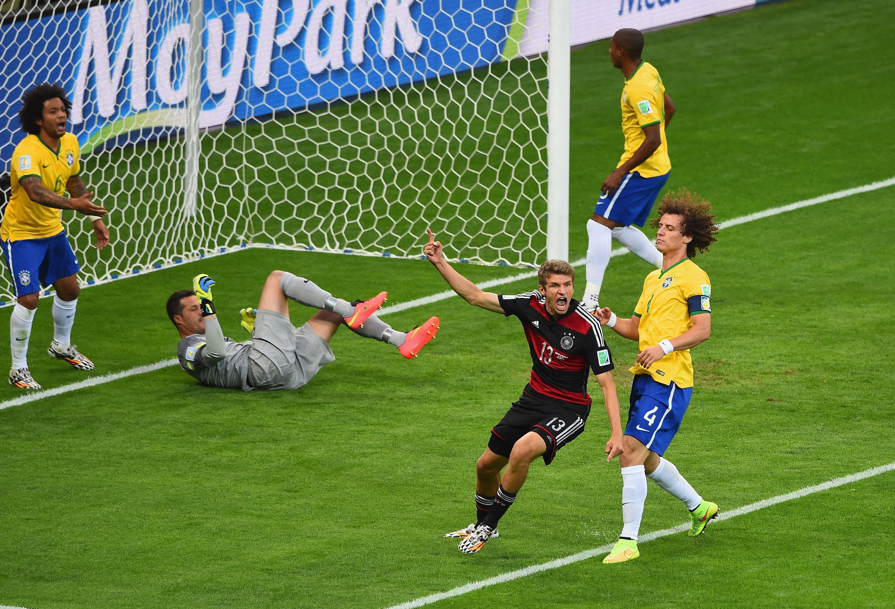 Thomas Mueller of Germany celebrates scoring his team's first goal past Julio Cesar of Brazil during the 2014 FIFA World Cup