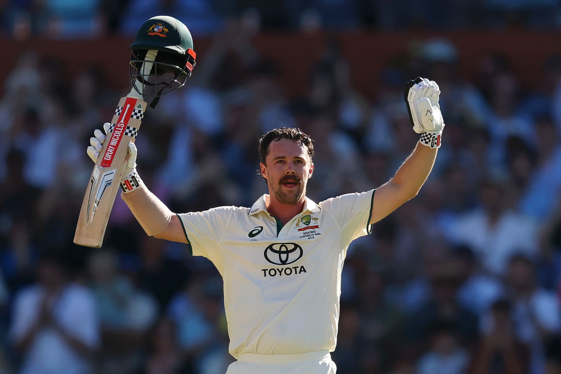 Travis Head of Australia raises his bat after scoring a century.jpg