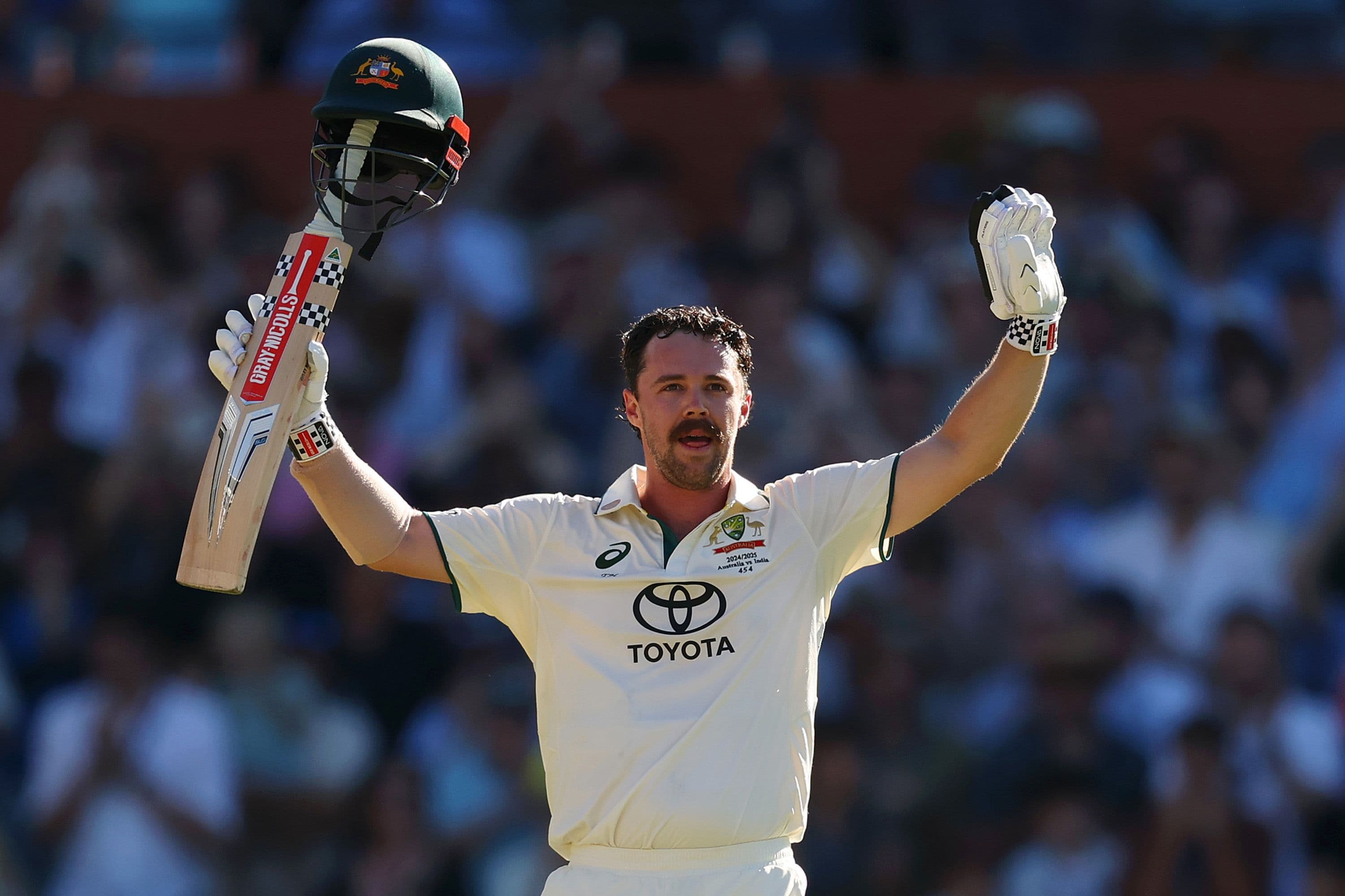 Travis Head of Australia raises his bat after scoring a century.jpg