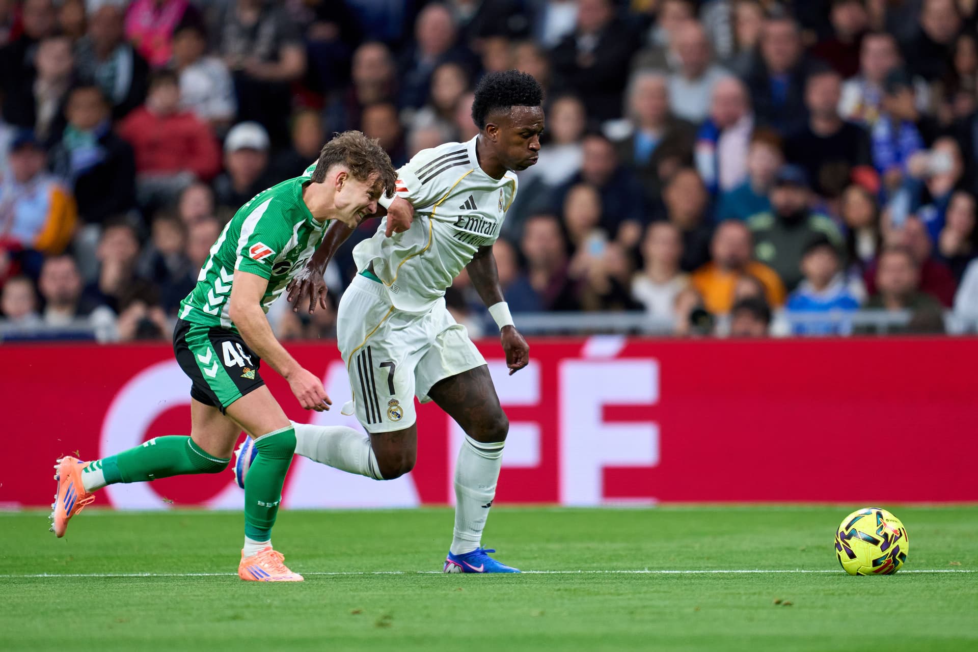 Vinicius Junior of Real Madrid competes for the ball with Angel Ortiz of Real Betis Balompie