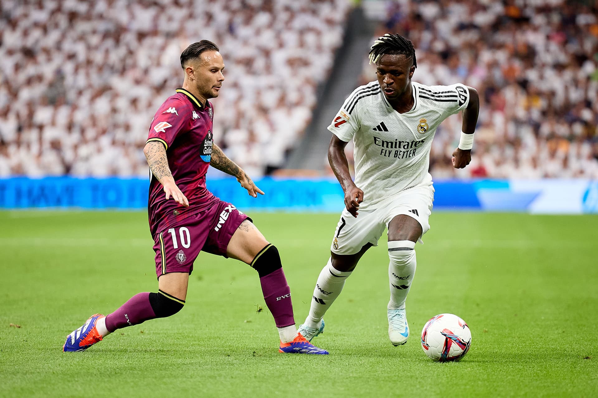 Vinicius Junior runs with the ball under pressure from Ivan Sanchez
