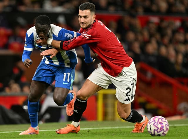 Yankuba Minteh (L) battles with Manchester United's Portuguese defender #02 Diogo Dalot (R)