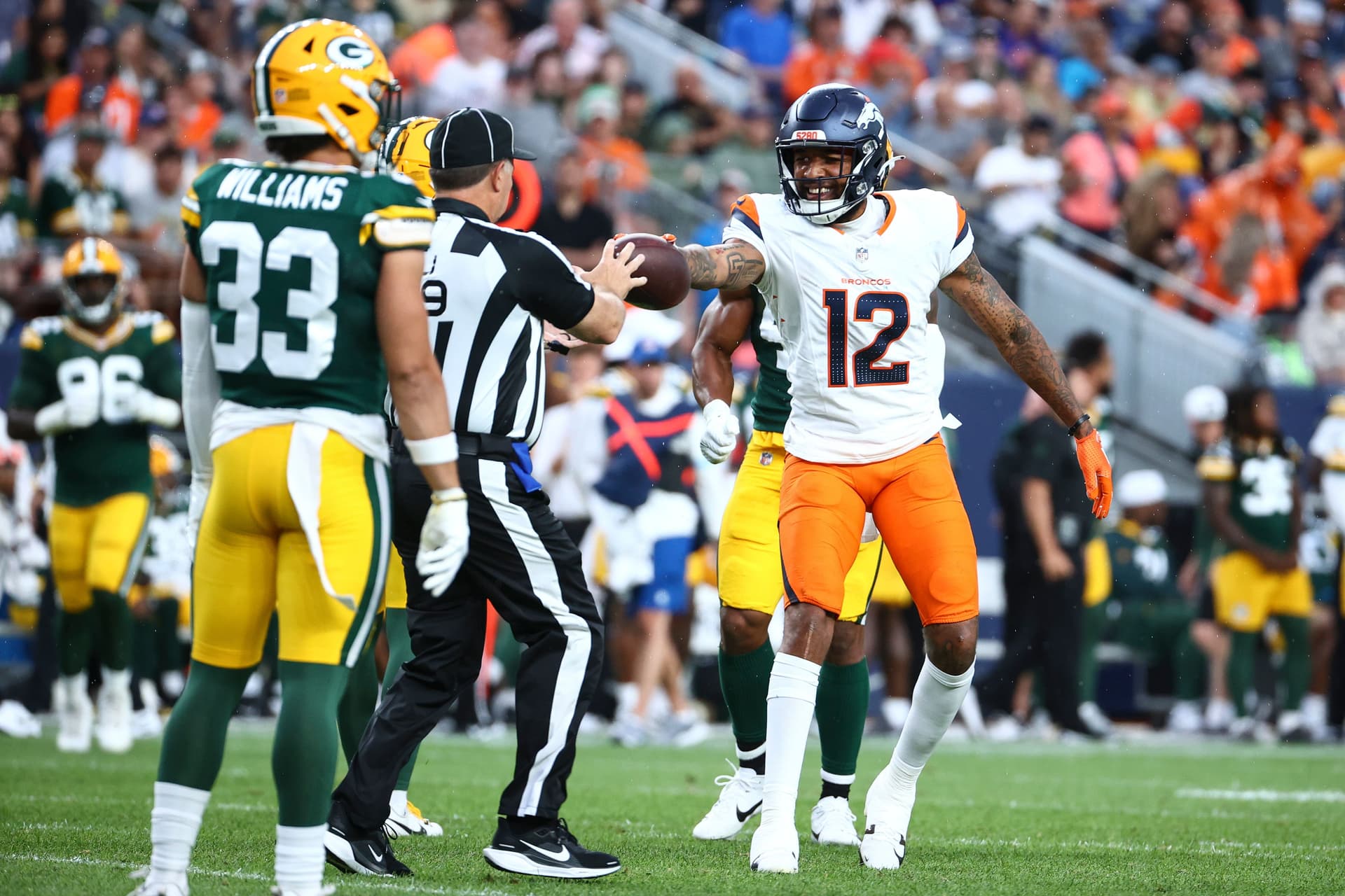 Tim Patrick hands the ball to a referee
