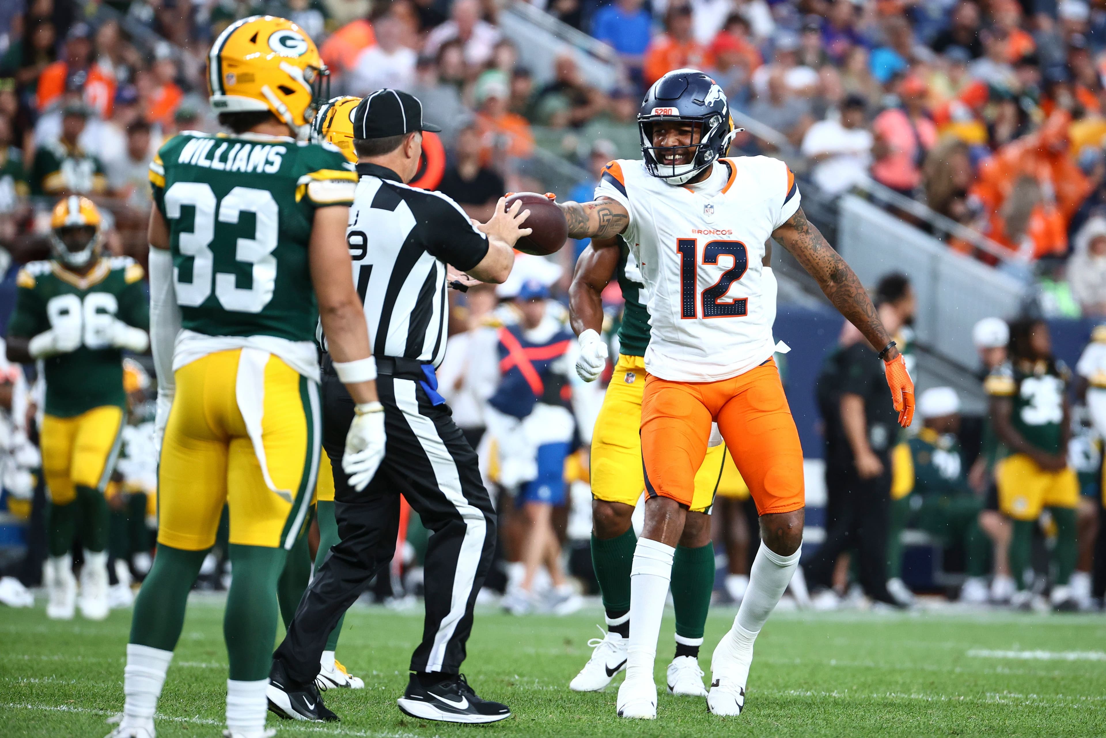 Tim Patrick hands the ball to a referee
